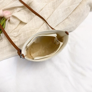 Close-up of woven bucket bag interior showing fabric lining and zippered inner pocket