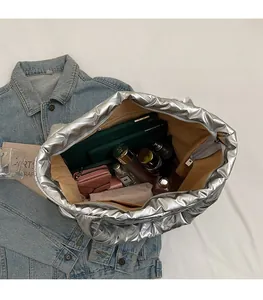 Top view showing the spacious interior of the silver tote bag with various daily essentials