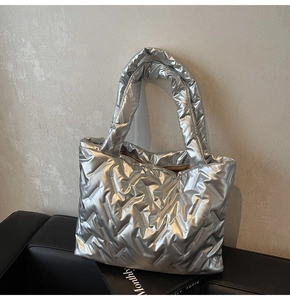 Detail of silver quilted tote bag with metallic finish and spacious padded design