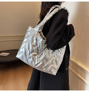 Detail of silver quilted tote bag with metallic finish and diagonal stitching texture
