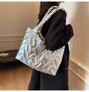 Detail of silver quilted tote bag showing its metallic glossy texture and padded pattern