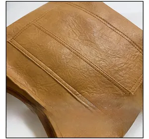 Detailed close-up of brown faux leather texture with neat double stitching on handbag