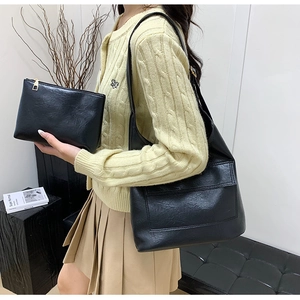 Detail of black leather tote bag set with matching pouch and large front pocket
