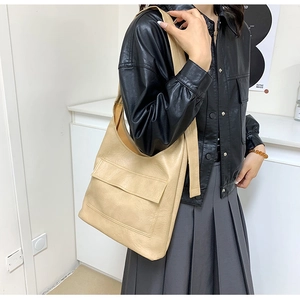 Detail of beige faux leather tote bag showing soft texture and large front flap pocket