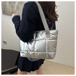 Gesteppte Tragetasche in Metallic-Silber mit breitem Schultergurt an einem Model