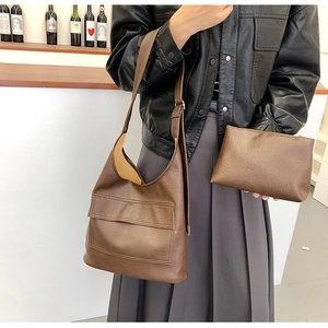 Detail view of large brown textured leather tote and matching zipper pouch for women