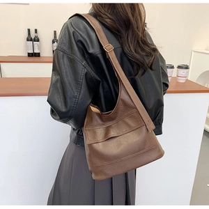 Brown vintage faux leather tote bag with adjustable strap shown on a model