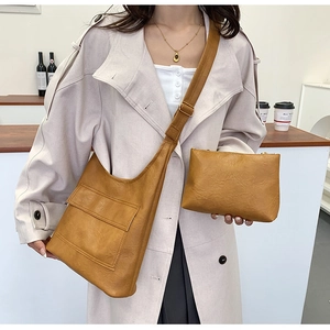 Detail view of mustard leather tote and clutch set with adjustable shoulder strap