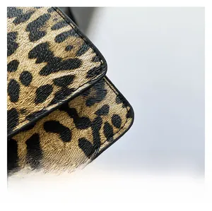 Vue macro du tissu à motif léopard avec bordure en cuir noir et texture grainée nette