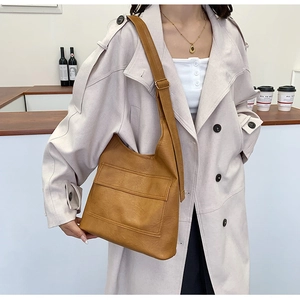 Detailed view of the brown PU leather shoulder bag with wide strap and utility pocket