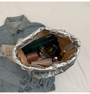 Detailed interior of silver quilted tote bag showing large capacity and zipper pocket