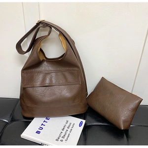 Detail of dark brown litchi grain leather tote bag with a matching zipper clutch purse