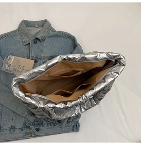 Top view of large silver puffer tote bag showing inner pockets and khaki lining detail
