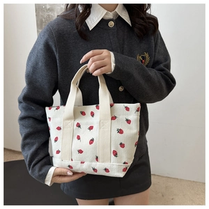 Detailed texture of corduroy handbag with sweet strawberry print and canvas handles
