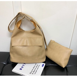 Detail view of khaki faux leather tote bag with matching zipper pouch and wide strap