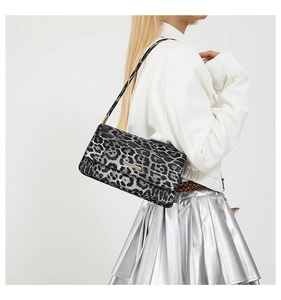 Détail d'un sac à bandoulière léopard avec barre métallique et rabat élégant