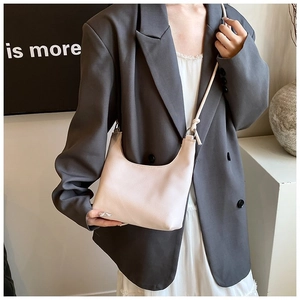Vista detallada del bolso hobo de piel beige con textura de grano y correa de nudo elegante