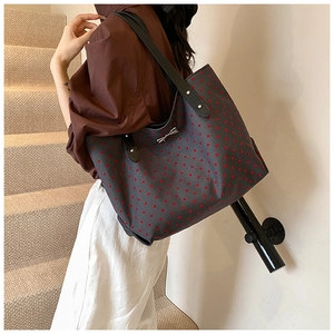 Bolso tote grande gris con lunares rojos, correas negras y detalle de lazo plateado