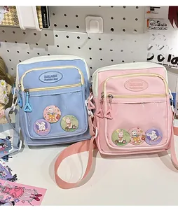 Detail of blue and pink clear ita bags with cute rabbit badges on a pegboard