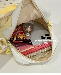 Internal view of a yellow canvas bag showing a mesh pocket, zipper, and phone storage