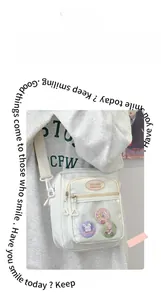 Detail showing white ita bag with clear window and cute rabbit badges for anime fans