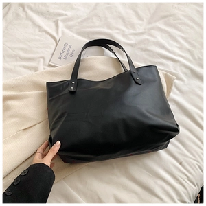 Detalle del interior espacioso y las asas con remaches de este bolso tote negro