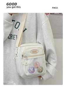Detail view of white ita bag showing transparent PVC window with cute rabbit badges