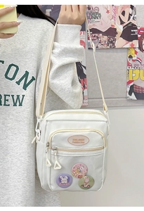 Detailed view of the white crossbody bag with transparent window and cute bunny badges