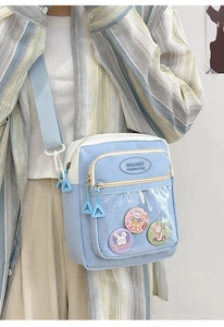 Detail of light blue ita bag showing transparent PVC window with cute rabbit badges