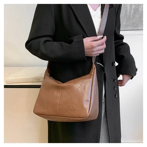 Nahaufnahme der braunen Vintage-Hobo-Tasche aus PU-Leder, getragen von einem Model