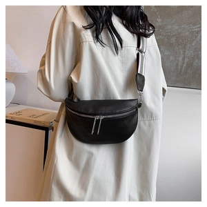 Détail du sac banane croissant en cuir noir avec large bandoulière rayée mode
