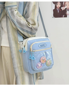Detail showing transparent PVC window of blue canvas ita bag with cartoon rabbit badges