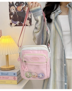 Detail of pink canvas ita bag with clear window showing cute rabbit badges and logo
