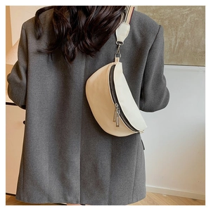 Détail du sac de poitrine blanc cassé avec texture litchi porté sur le dos du mannequin