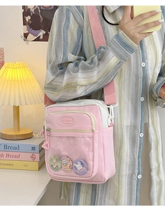 Pink and white canvas bag with transparent window and cute bunny badges shown on shoulder