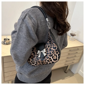 Dettaglio della borsa hobo leopardata con fibbia a fiocco argento sulla spalla