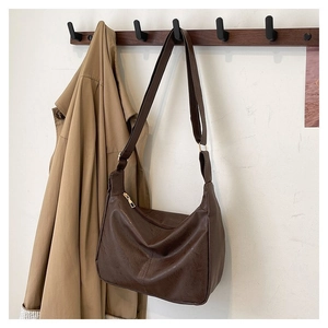 Detailansicht der großen dunkelbraunen Hobo-Tasche mit verstellbarem Gurt am Kleiderbügel