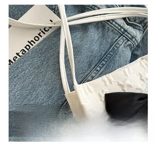 Detail of white tote bag with star jacquard fabric and black satin ribbon bow decoration