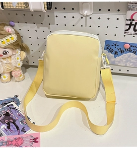 Detail of a yellow crossbody ita bag with adjustable strap on a cute aesthetic desk setup