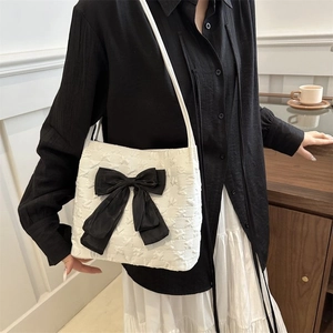 Detail showing white bubble texture fabric and large black bow decoration on tote bag