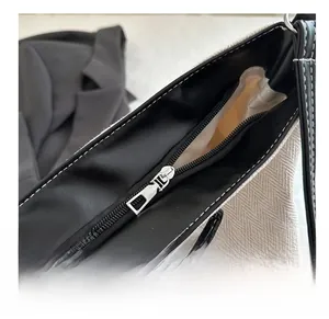 Close-up of smooth silver zipper and contrast stitching on a canvas tote bag