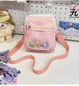 Detail of pink ita bag with transparent window featuring cute cartoon rabbit pins