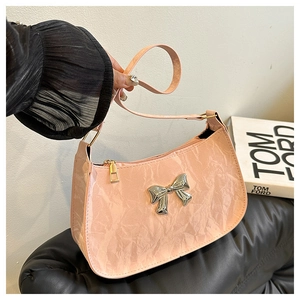Dettaglio borsa sottobraccio in pelle rosa stropicciata con fibbia a farfalla in metallo