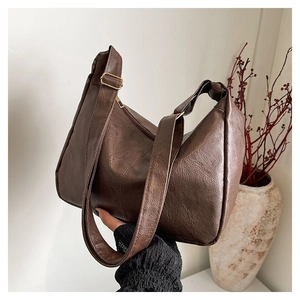Detailansicht einer braunen Shopper-Tasche aus strukturiertem Leder mit goldener Schnalle