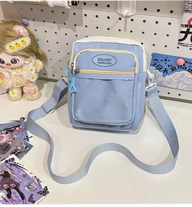 Detail view of the clear PVC window and blue-white contrast on the small crossbody bag