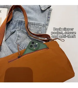 Sac bandoulière en nylon marron avec une poche zippée antivol au dos pour grand smartphone