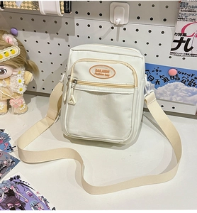 Detail view of a white canvas ita bag with a clear PVC front pocket and zipper compartments