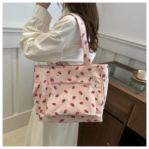 Dettaglio della borsa tote in velluto rosa con stampa di fragole e tasca frontale zip
