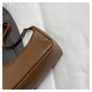 Detailansicht der braunen PU-Ledertasche mit Vintage-Struktur und feinen Nähten