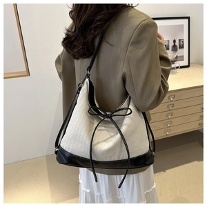 Close-up of minimalist canvas tote bag with herringbone texture and black leather trim